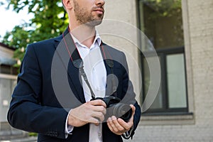 cropped view of photojournalist in formal wear with digital