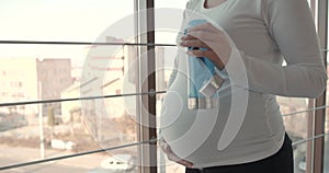 Cropped view of pregnant woman with plastic bottle