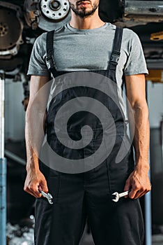 cropped view of professional auto mechanic holding two wrenches
