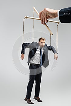 Cropped view of puppeteer holding businessman