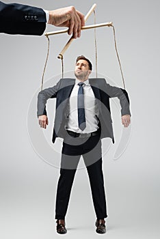 Cropped view of puppeteer holding businessman