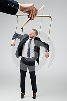 Cropped view of puppeteer holding businessman