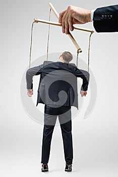 Cropped view of puppeteer holding businessman