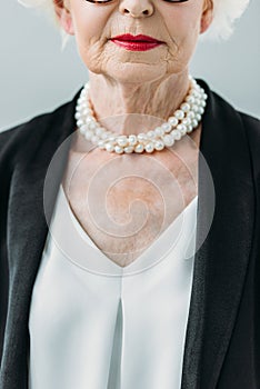 cropped view of senior lady in pearl necklace,