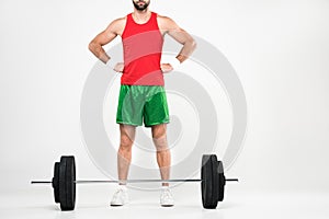 cropped view of sportsman in retro sportswear standing near barbell