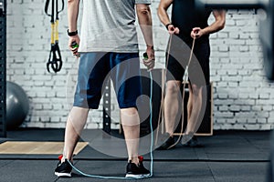 cropped view of sportsmen training with skipping rope