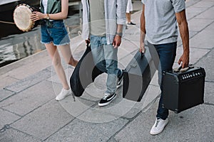 Cropped view of street musicians walking and carrying