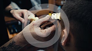 Cropped view of tattooed hairdresser trimming