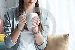 cropped view of teen girl with cup