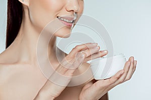 cropped view of woman applying face cream
