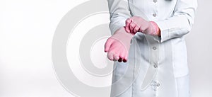 Cropped view of Woman Doctor in uniform putting on pink sterile gloves  on white background