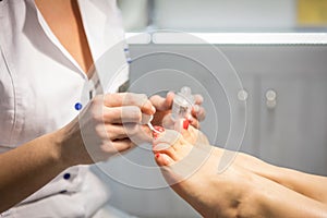 Cropped view of woman getting a pedicure at beauty salon