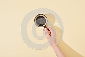 Cropped view of woman holding cup of fresh coffee