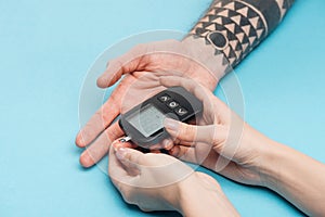 Cropped view of woman testing man blood sugar level with glucometer