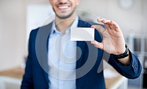 Cropped view of young Arab man showing empty business card with mockup for design at modern office