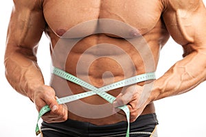 Cropped view of young muscular man with measuring tape