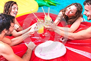 Cropped view of young people drinking fruit cocktails at pool party - Luxury vacation concept with guys and girls having fun