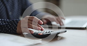 Cropped view of young woman hands makes calculations