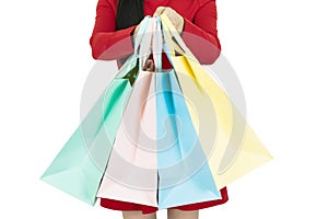 Cropped view of young woman in red coat holding colorful shopping bags isolated on white, closeup.Huge sale, seasonal discounts,