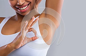 Cropped of woman looking at shaved armpit, showing okay gesture