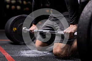 Cropped young athlete getting ready for crossfit training, hands in talc