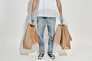cropper view of delivery man who holds a lot of paper bags