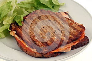 Croque-monsieur served in a plate with salad close-up on white background