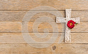 Cross background, religious christian stone cross and rose blossom on wood for death and grief concept