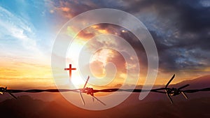 Cross and barbed wire against sunset over mountain landscape 3d render