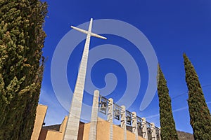 Cross and bells in the Sanctuary of Saint Pio from Pietrelcina, Apulia, Italy.