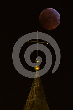 Cross below a moon eclipse