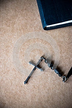 Cross and the Bible on brown paper background.