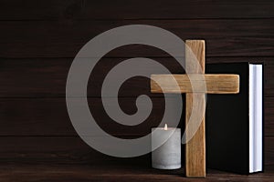 Cross, Bible and burning candle on background, space for text. Christian religion