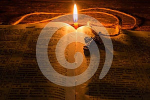 Cross on the Bible by candlelight selective focus