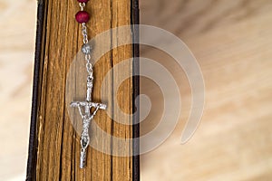 Cross on the Bible on a wooden background. Holy book