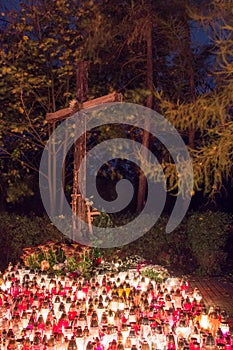 Cross with candles on Polish cemetery during All Souls` Day at night.