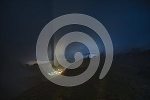 The Cross of Caraiman reflected on the clouds in the night time under the moonlight from Bucegi