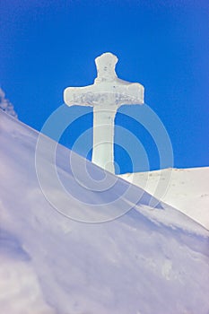 Cross christian symbol made from a block of ice on top of the ice church