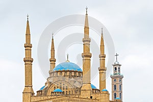 Cross on a church tower and al-Amin mosque`s minarets and dome, Beirut, Lebanon photo