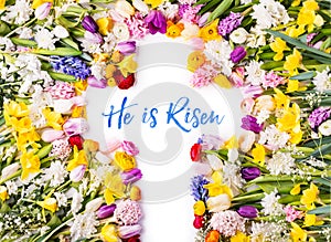 A cross on a colorful flower background. Easter flat lay.