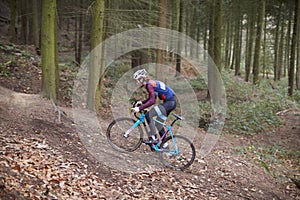 Cross-country cyclist ascending a slope in a forest