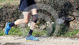 Cross-country runner during the race with his knee wrapped