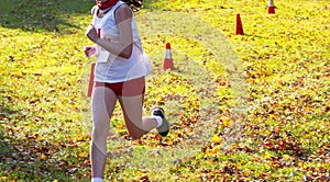 Cross country runner running on grass in bright sunshine