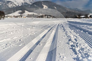 Cross-country skiing in Austria: Slope, fresh white powder snow and mountains, blurry background