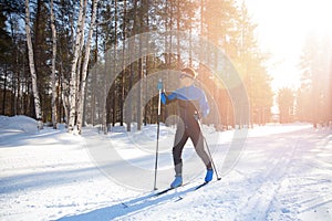 Cross country skiing, happy man skier active winter sport on snowy track, sunset background