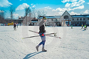 Cross-country skiing woman doing classic nordic cross country skiing in trail tracks in snow covered forest