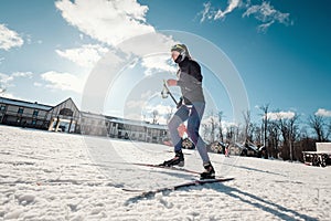 Cross-country skiing woman doing classic nordic cross country skiing in trail tracks in snow covered forest