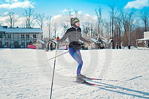 Cross-country skiing woman doing classic nordic cross country skiing in trail tracks in snow covered forest