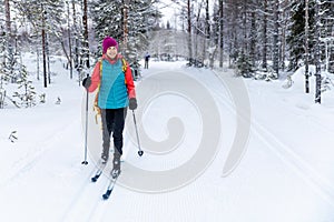 Cross country skiing - woman with skis on snowy forest ski track. Akaslompolo, Finland