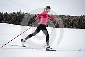 Cross-country skiing: young woman cross-country skiing on a winter day